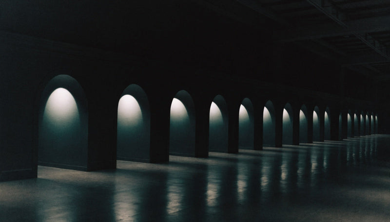 A dark hall lined with many lit alcoves — editorial illustration (AI-generated)