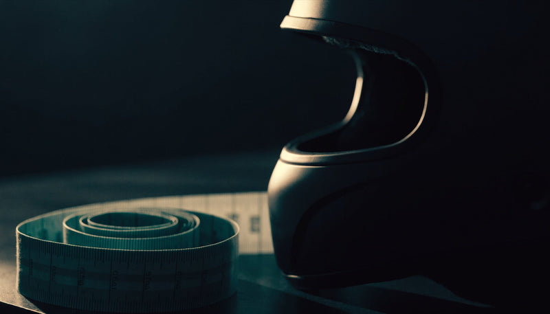 Measuring tape coiled beside a full-face helmet